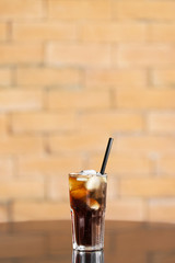 Glass of cold cola on table