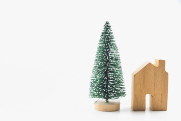 Tiny christmas tree and wooden house toy isolated on white background.