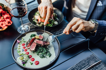 Close up photo, man ready to eat medium rare beef steak while sitting in modern restaurant.