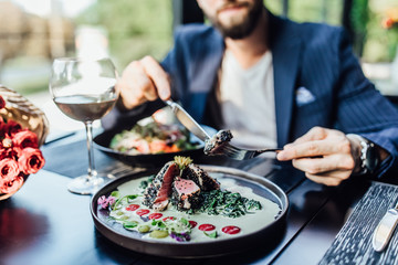 Close up photo, man ready to eat medium rare beef steak while sitting in modern restaurant, healthy...
