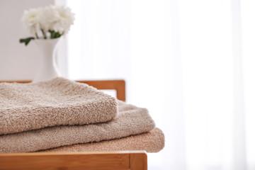 Fototapeta na wymiar Stack of clean towels on table in room