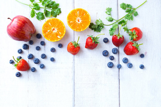 Fruits And Vegetable Blueberry, Strawberry, Apples, And Orange On White Wood Background.Healthy And Lifestyle Concept.Top View.