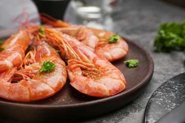 Plate with tasty shrimps on grey table