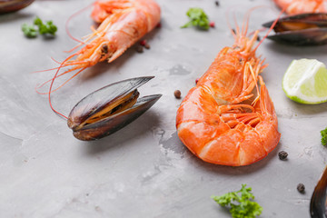 Tasty shrimps with mussels and spices on grey background