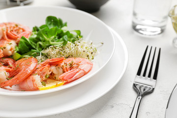 Plate with tasty shrimps on table