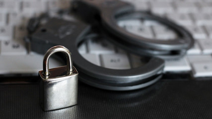 the silver handcuffs, metal lock and white notebook