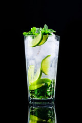 classic mojito cocktail with reflection on a dark background