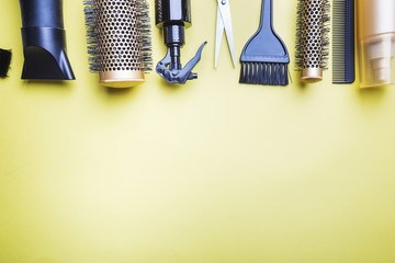 Various hair dresser and cut tools on yellow background with copy space