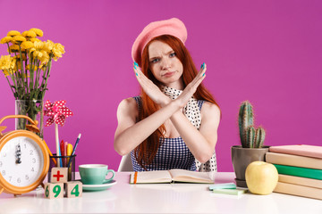 Image of displeased teenage girl showing arms crossed while studying