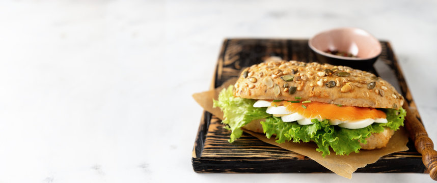 Healthy sandwich with salmon on white background
