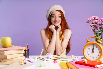 Obraz na płótnie Canvas Photo of joyful student girl sitting at desk with exercise books