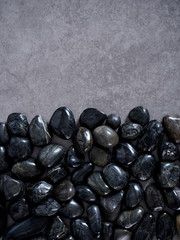 Pebbles black on gray marble background.