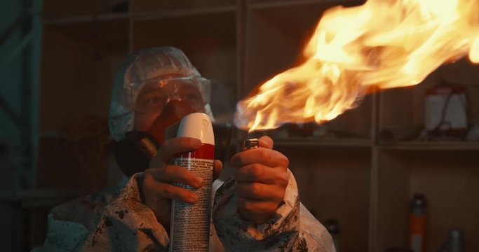 man splashes a flame of fire from an aerosol can