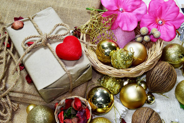 Fototapeta na wymiar Gift boxes, Christmas tree golden ball,red heart put on sackcloth. Preparing to celebrate Christmas.