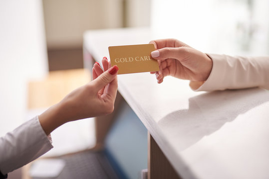 Young woman using gold card to pay for purchases
