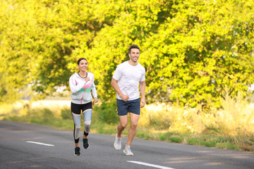 Obraz premium Sporty young couple running outdoors