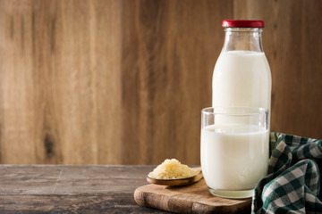 Rice milk in glass and bottle on wooden table. Copyspace