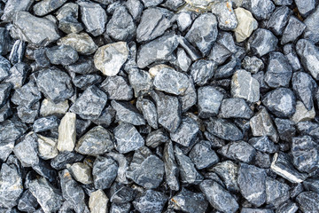 Small rocks or gravel made from  stones different shape as stone texture. Used for construction of buildings and roads and as a building material.