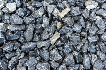 Small rocks or gravel made from  stones different shape as stone texture. Used for construction of buildings and roads and as a building material.
