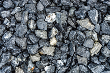 Small rocks or gravel made from  stones different shape as stone texture. Used for construction of buildings and roads and as a building material.