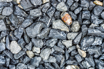 Fototapeta na wymiar Small rocks or gravel made from stones different shape as stone texture. Used for construction of buildings and roads and as a building material.