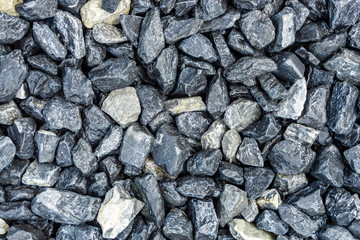 Small rocks or gravel made from  stones different shape as stone texture. Used for construction of buildings and roads and as a building material.