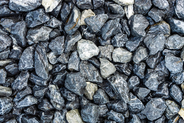 Small rocks or gravel made from  stones different shape as stone texture. Used for construction of buildings and roads and as a building material.