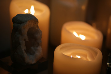 Burning candles on a nice table in the dark