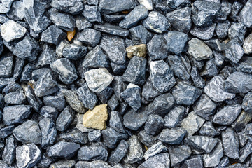 Small rocks or gravel made from  stones different shape as stone texture. Used for construction of buildings and roads and as a building material.