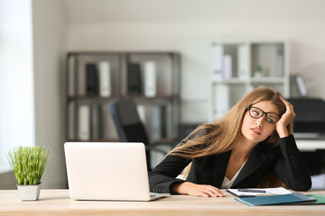 Stressed young woman at workplace