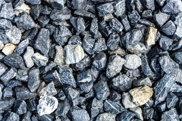 Small rocks or gravel made from  stones different shape as stone texture. Used for construction of buildings and roads and as a building material.