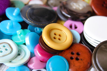 Old multi-colored plastic buttons for clothes. Top view. Close-up. Background. Texture.