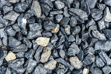 Small rocks or gravel made from  stones different shape as stone texture. Used for construction of buildings and roads and as a building material.