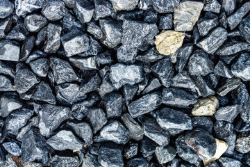 Small rocks or gravel made from  stones different shape as stone texture. Used for construction of buildings and roads and as a building material.