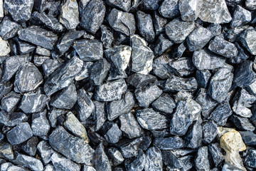 Small rocks or gravel made from  stones different shape as stone texture. Used for construction of buildings and roads and as a building material.