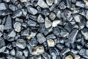 Small rocks or gravel made from  stones different shape as stone texture. Used for construction of buildings and roads and as a building material.