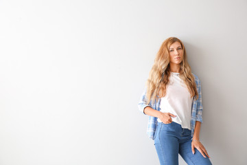 Beautiful young woman on light background