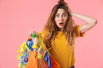 Photo of frightened nice woman holding bag with plastic waste