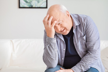 Senior man suffering from headache at home