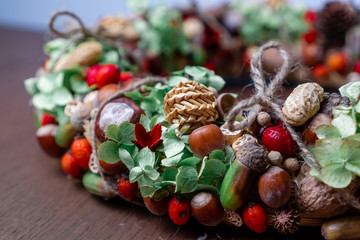 Handmade autumn wreath with greenery, nuts and rose-hips