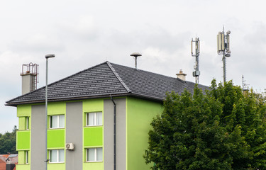 Fototapeta na wymiar 5G antennas on top of house. Antennas and transmitters on roof.