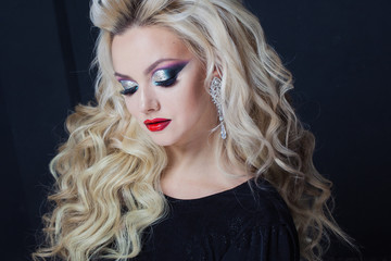 Fototapeta premium Portrait of a young luxurious blonde with long curls.