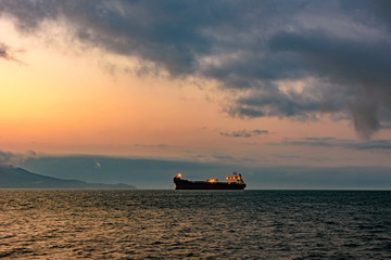 Cargo ship anchored in the waters of Ilhabela Island at dusk with the mountains in the background