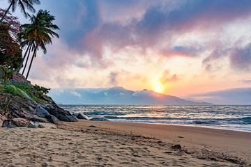 Sunset behind the mountains on a beach on Ilhabela Island in the north coast of Sao Paulo, Brazil