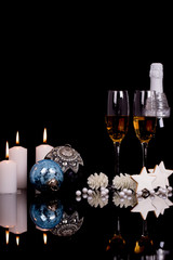 Two wine glasses with champagne, Christmas ornaments, gingerbread in the shape of stars and candle