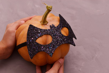 Halloween pumpkin head. Pumpkin head in a bat mask.