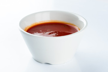 tomato ketchup sauce in a bowl on a light background