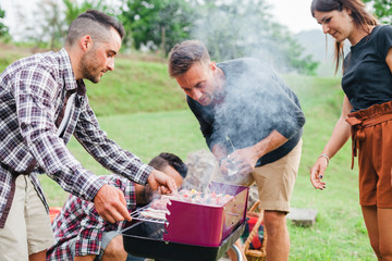 Group of friends doing a barbecue in the countryside