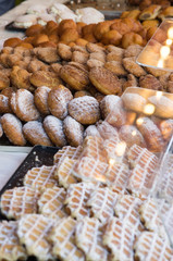 Delicious waffles, sugared buns and donuts for sale in the shop window