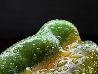 bell pepper on a black background. Bulgarian pepper on a black background with water drops.